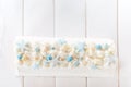 Beautiful white cake roll in front of a white background. The cake has snowflake-shaped confectionery decorations Royalty Free Stock Photo