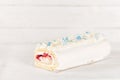 Beautiful white cake roll in front of a white background. The cake has snowflake-shaped confectionery decorations Royalty Free Stock Photo