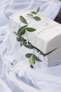 Beautiful white casket in a vintage style of standing on a white cloth with a sprig of a tree on the cover Royalty Free Stock Photo