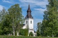 The beautiful white church in Ockelbo surrounded by lush green trees