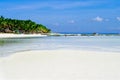 Beautiful white coral sand beach with palms and cottages, turquoise blue ocean Royalty Free Stock Photo