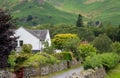 Beautiful white cottage house on the green farmlands at the Lake District area in United Kingdom Royalty Free Stock Photo