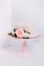 Beautiful white cream cake decorated with 2 year old candle and roses in white studio. Birthday party - Concept of a year of birth Royalty Free Stock Photo