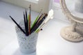 A beautiful, white cup with openwork patterns for storing brushes for make up