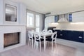 Beautiful white dining area and kitchen with massive dining table and six chairs for with window and modern electric Royalty Free Stock Photo