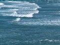 Beautiful white foam on turquoise tidal waves. The surface of the water as a background. Blue ocean water Royalty Free Stock Photo