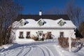 Beautiful white french-style ancestral house with green trimmed windows and door with Christmas decorations