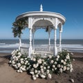 Beautiful white gazebo on the beach by the sea, twined with white rose flowers, a beautiful place for special occasions,