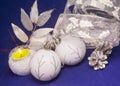 Beautiful white glass New Year`s balls with a silver pattern, white brilliant tinsel, cone a on a blue background - New Year`s com Royalty Free Stock Photo