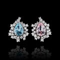 Beautiful white gold earrings with diamonds, aquamarine and morganite on a black background Royalty Free Stock Photo