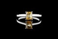 Beautiful white gold ring with yellow sapphire and diamonds on a black background Royalty Free Stock Photo