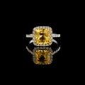 Beautiful white gold ring with yellow sapphire and diamonds on a black background Royalty Free Stock Photo