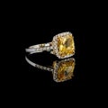 Beautiful white gold ring with yellow sapphire and diamonds on a black background Royalty Free Stock Photo