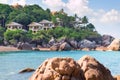 Beautiful white hotel houses on a rocky hill on the shore of Koh Samui Thailand buried in verdure against the backdrop of the