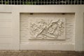 Beautiful white Java stucco patterned on the boundary wall. Vintage white wall bas-relief stucco in plaster, depicts Lotus flower Royalty Free Stock Photo