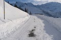 Beautiful white landscape, Swiss Alps, wide alpine winter road cleared, large snowdrifts on the side, snowfall in in the city,