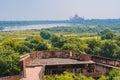 beautiful white marble Taj Mahal is seen from the Red Fort . In the foreground are green fields, a river, blue sky. Royalty Free Stock Photo