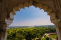 beautiful white marble Taj Mahal is seen from the Red Fort . In the foreground are green fields, a river, blue sky. Royalty Free Stock Photo