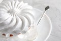 Beautiful white meringues with a silver spoon on a white plate. White cake Royalty Free Stock Photo