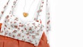 Beautiful white otange set of female clothes top view. Floral top, orange clothes. Set of clothing laying flat Royalty Free Stock Photo