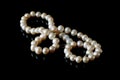 Beautiful white pearls necklace on black background, top view Royalty Free Stock Photo