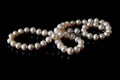 Beautiful white pearls necklace on black background, top view Royalty Free Stock Photo