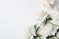 Beautiful white peony flowers bouquet on pastel table top. Flat lay style.