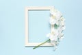 Beautiful White Phalaenopsis orchid flowers, wooden white photo frames on blue background top view flat lay. Tropical flower, Royalty Free Stock Photo