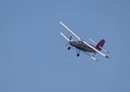 A beautiful white plane flies against a blue sky