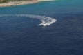 Beautiful white pleasure boat with driver leaving a wide wake in the sea