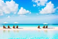 beautiful white sand beach with chaise lounge and umbrella. Generative AI Royalty Free Stock Photo