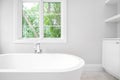 A white standalone tub in a luxury bathroom.