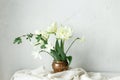 Beautiful white tulips and daffodils on wooden table against rustic wall. Happy Mothers day. Stylish simple spring bouquet in Royalty Free Stock Photo