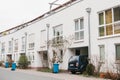 Beautiful white two-storey house with bushes and garbage cans and parked car. Germany.