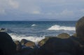 Beautiful white waves in blue sea impact big stones on the shore Royalty Free Stock Photo