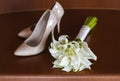 Beautiful white wedding bouquet of lilies lies next to the bride`s shoes Royalty Free Stock Photo