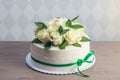 Beautiful white wedding cake decorated with bouquet of flowers white roses. Concept of elegant holiday desserts