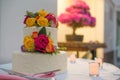 Beautiful white wedding cake with real flowers surrounded by candles Royalty Free Stock Photo