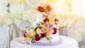 Beautiful white wedding cake with red roses as decoration. Royalty Free Stock Photo