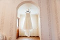 Beautiful White Wedding Gown Hanging by Window