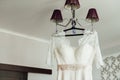 Beautiful White Wedding Gown Hanging by Window