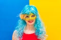 Beautiful white woman dressed for a Carnival night. A smiling girl in a blue wig and yellow mask is going to celebrate a Royalty Free Stock Photo