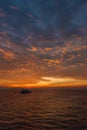 Beautiful wide twilight sunset evening sky reflect on sea water with silhouette boat in ocean and epic cloud pattern background