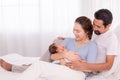 Beautiful wife leaning her back to husband leg while hold newborn with love and carefully, happy Hispanic father with beard or mix Royalty Free Stock Photo