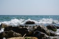 Beautiful wild beach landscape, sunny day, water waves hitting the cliffs, nature summertime scene