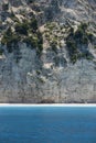 Beautiful wild Mediterranean pebble beach under a large rock