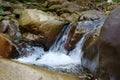 Beautiful little waterfall in mountains. Water flows between stones Royalty Free Stock Photo