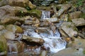 Beautiful little waterfall in mountains. Water flows between stones Royalty Free Stock Photo