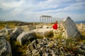 Beautiful wild red poppy flower on the rock with blurry ancient ruin of laodicea in the background.