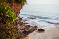 Beautiful wild sea shore with a cliff covered by tropical green. Ocean beach with white sand and rocks. Beautiful Royalty Free Stock Photo